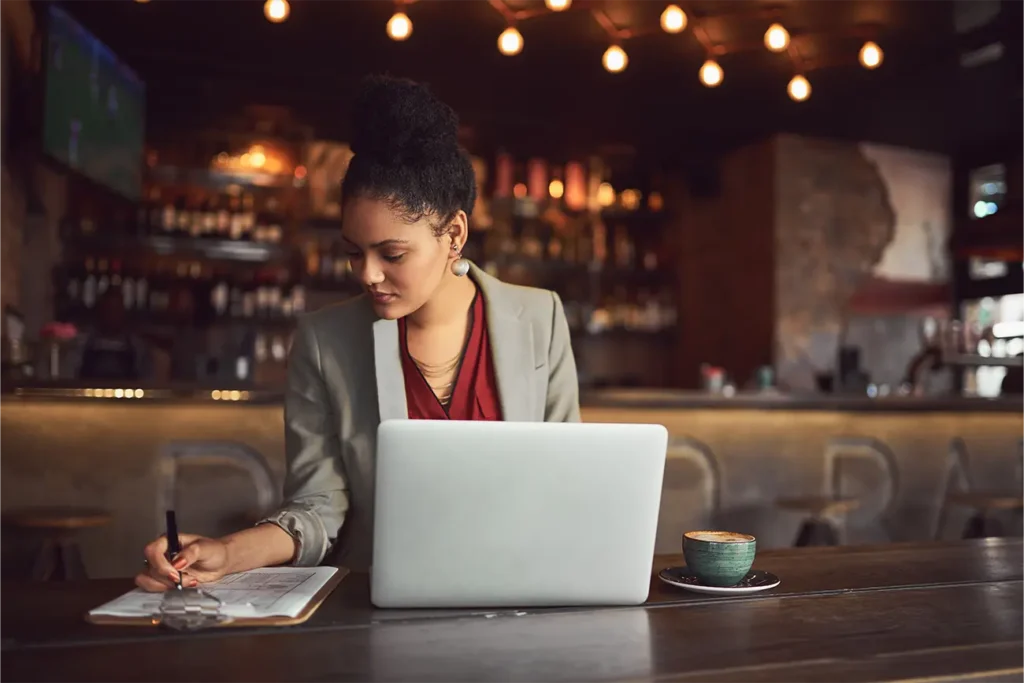 Young Beautiful first time entrepreneur working on her business in a coffee shop