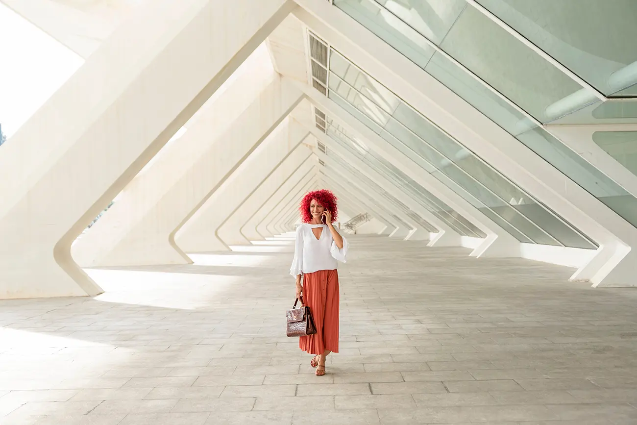 trendy entrepreneur walking under modern architecture deciding the cash needed for a new business